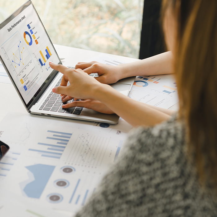 Two people reviewing charts and graphs on a laptop and printed reports — highlighting actionable insights from bill validation.